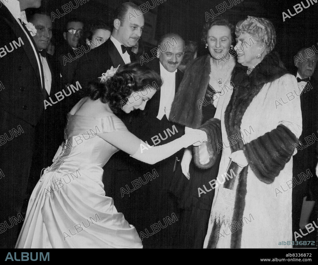 "Queen Mary Attends" "Corridor Of Mirrors: Premiere - In a full length off-the-shoulder Edwardian gown Edna Romney Curlseys to H.M. Queen Mary, at the Odeon Premiere, this evening. H.M. Queen Mary attended the Premiere of the new film "Corridor of Mirrors" at the Odeon, Leicester-square, this evening (Thursday). The film introduces South African Edana Romney who at 26, is making her screen debut in her won film. Edana adapted the screen-play from a novel by C. Massie, and co-stars with Eric Portman. March 11, 1948. (Photo by Reuterphoto).