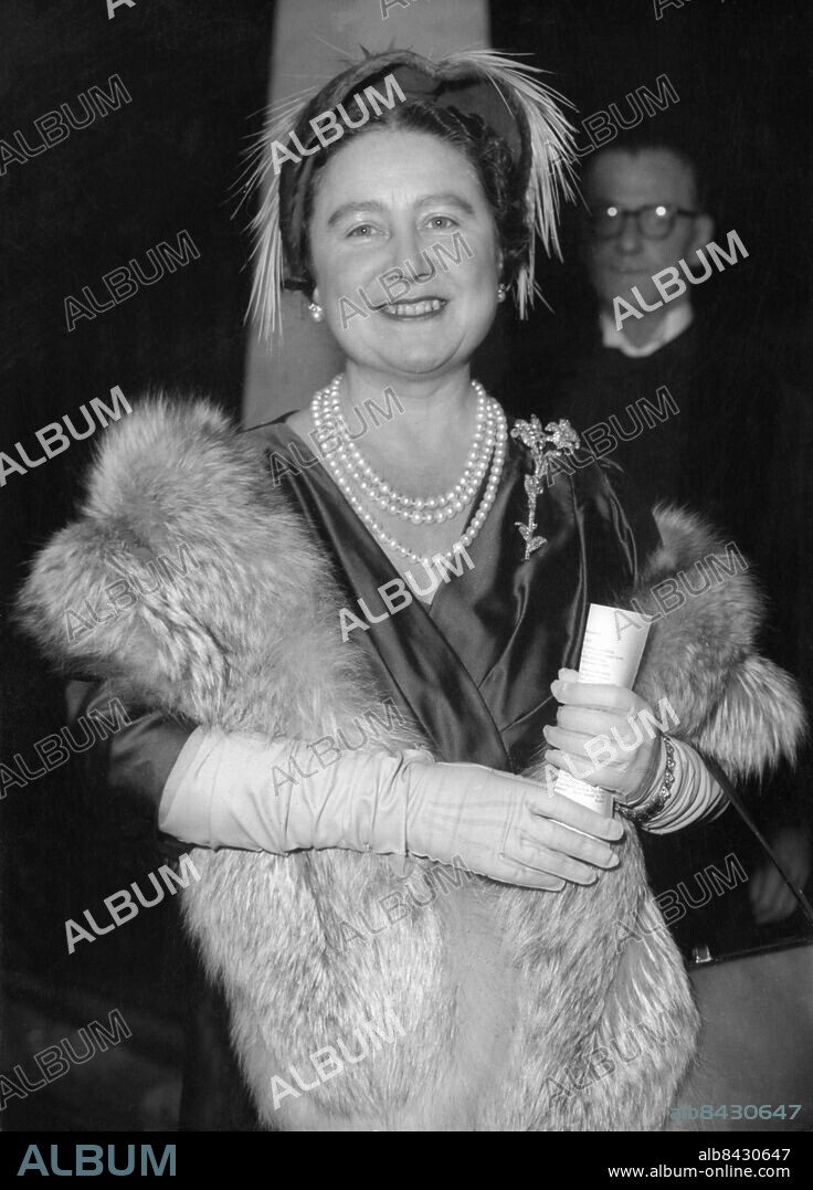 Orig. bildtext... QUEEN MOTHER AT LONDON WEDDING. The Queen Mother, making her first public appearance since her return from America and Canada, went to St. Margaret's, Westminster, yesterday to attend the wedding of Miss Mary Roche, elder daughter of Lord and Lady Fermoy, and the Hon. Anthony Berry, youngest son of Lord Kemlsey, the well known British newspaper proprietor. PHOTO SHOWS. Queen Elizabeth, the Queen Mother, wearing a dress of steel blue and matching hat trimmed with pink feathers, arrives for the wedding. Nov. 26. 54. Anm. E Bowes-Lyon, 1900-2002, brittisk drottning 1936-1952 och maka till kung Georg VI, kallad drottningmoder när äldsta dottern tillträdde som drottning Elizabeth II 1952. Pärlhalsband Örhängen Broscher Armband Handskar Fjädrar Leenden Siden CD514 persons: ELIZABETH, DROTTNINGMODER sites: LONDON;STORBRITANNIEN.