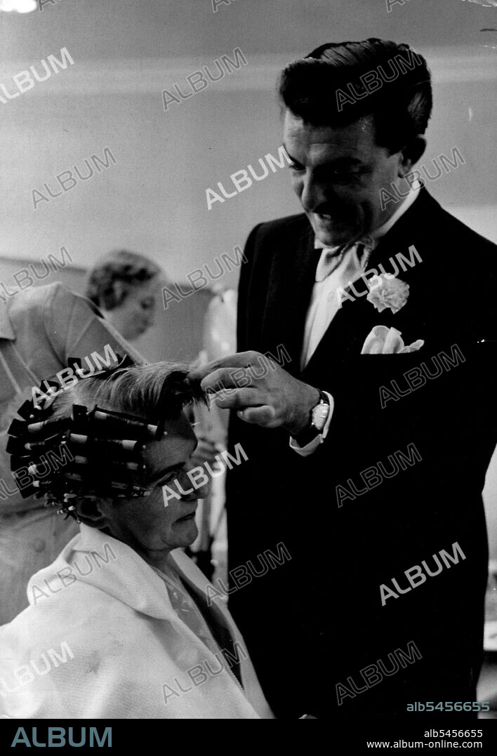 Raymond A customer is given a Yeast-ray perm - one of Raymond's newest time-saving inventions.
Most of the products his salons use are either from his own formulas or suggestions. Latest is yeast to swell the hair under gentle heat. It takes half as long as an ordinary perm. December 29, 1954. (Photo by Joe Waldorf).