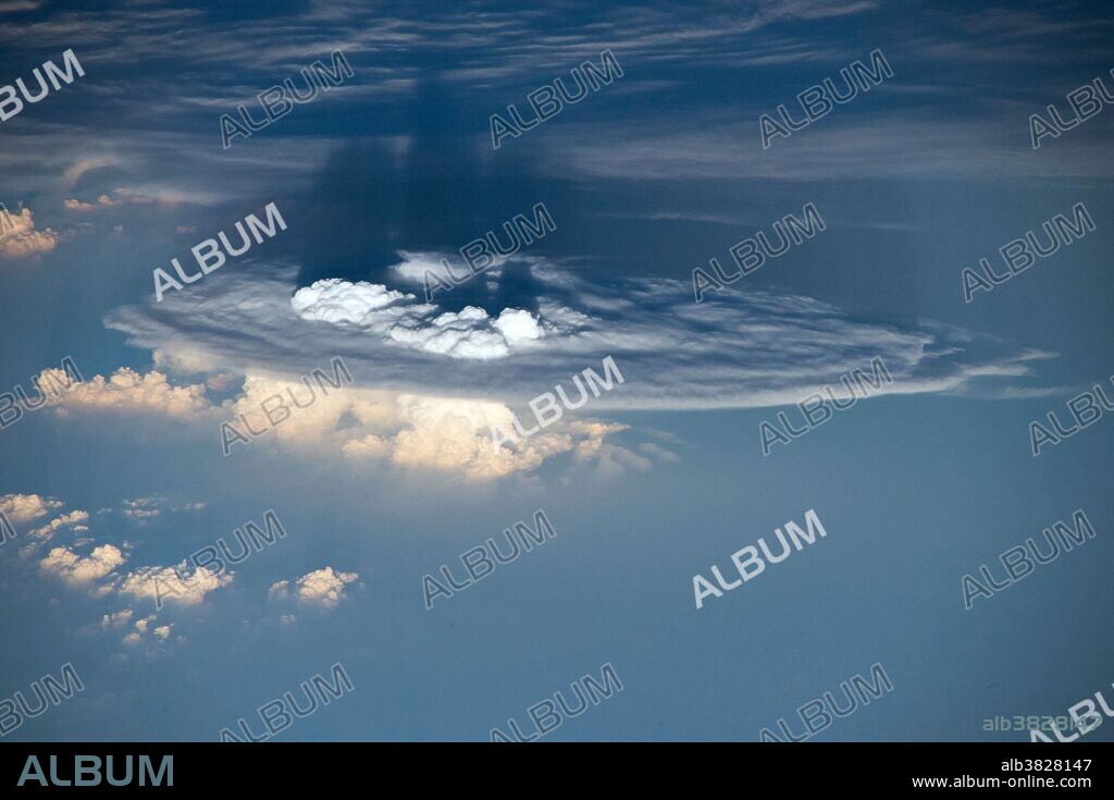 The bright formations above the flat part of this cumulonimbus cloud are called overshooting cloud tops. Overshooting tops occur when forces push the clouds up through the troposphere, the lowest region of the atmosphere, and into the stratosphere.