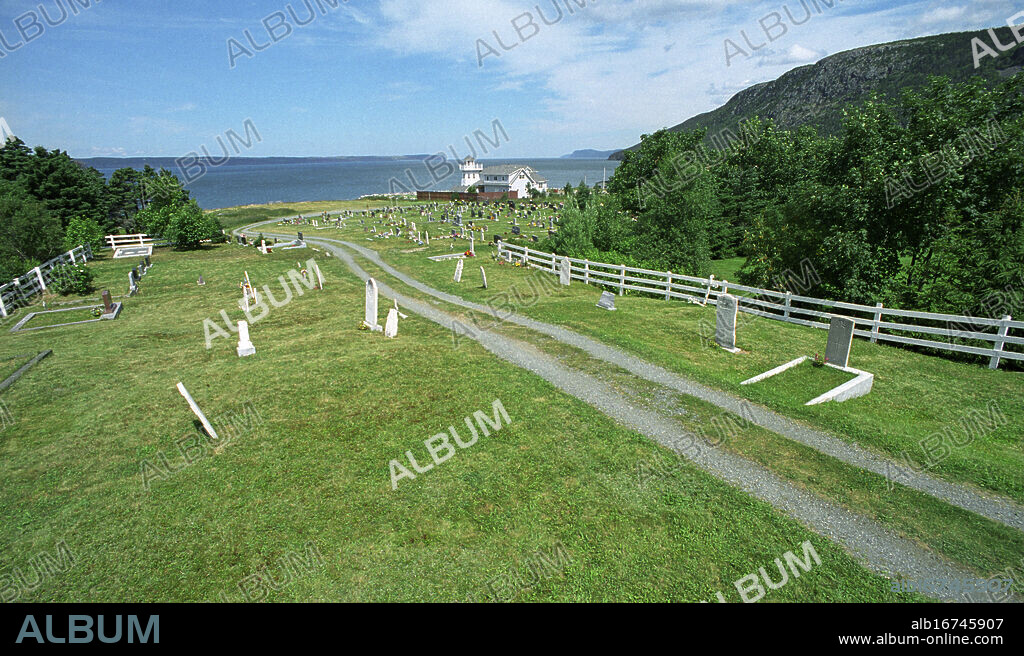 TOPSAIL ST THOMAS OF VILLANOVA RC CEMETERY, TOPSAIL NORTH OF ST JOHNS, NEWFOUNDLAND, CANADA. THE LONE CWGC GRAVE OF PRIVATE GREGORY NEVILLE DIED 3 JULY 1918. LIGHT GREY HEADSTONE TO RIGHT OF WHITE HEADSTONE WITH CUT INDENTS AGAINST WHITE PAINTED FENCE BACK RIGHT OF PHOTOGRAPH. COPYRIGHT PHOTOGRAPH BY BRIAN HARRIS © 2006. 07808-579804.