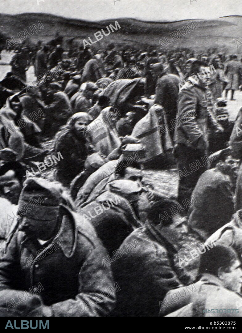 Black and white photograph of World War II (1939-1945); Yugoslav prisoners sitting in a field during the invasion of Yugoslavia in April 1941 by Germany.