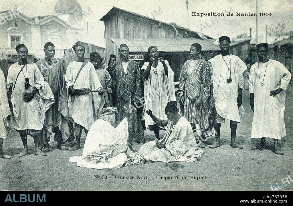 Zoo humain de l'Exposition de Nantes : 'Village noir. La partie de piquet'. Photographie anonyme pour une carte postale de 1904. Credit : Collection IM/KHARBINE-TAPABOR.