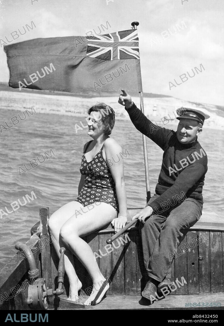 Orig. bildtext... SALLY BAUERS KANALSIMNING. George Obree, som skall ledsaga Sally över kanalen, visar henne kursen. Orig. bildtext... SWEDISH GIRL SWIMMER TRAINS FOR RECORD CHANNEL ATTEMPT. Sally Bauer, 26-year-old Swedish champion swimmer, has arrived at Dover to train for an attempt on the record for a cross-Channel swim. she is confident she break the record. O.P.S. George Obree, who is in charge of the swim, showing Sally Bauer the tides just outside Dover harbour today. Anm. CD75 och CD112 Simmare Långdistanssimmare Kanalsimmare Båtar Baddräkter Kanalsimning Simsport v24a Kort ung film: Kanalsimmerskan sänds i SVT2 2000-06-18 persons: Sally Bauer ;George Obree sites: STORBRITANNIEN* ;SVERIGE*.