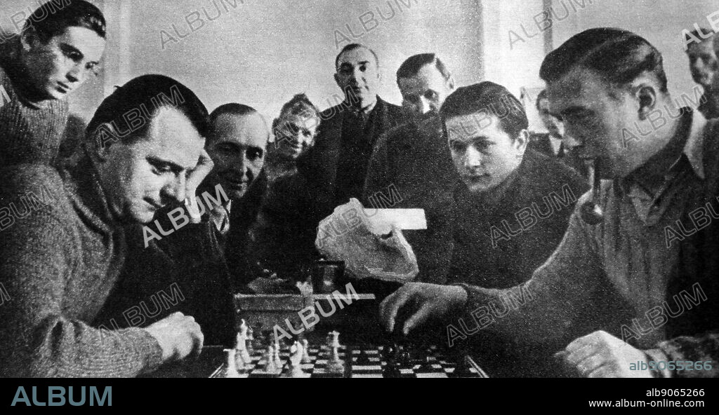 British soldiers playing chess in a Wulzburg German prisoner of war camp during World War II. The Red Cross provided the games and cards.