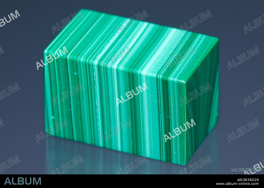 A cut and polished cube of malachite. Malachite is a copper carbonate mineral. Specimen Dimension: 2 x 2 x 1 cm.