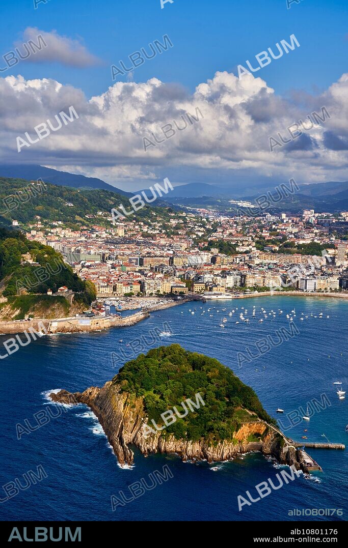 Vista de la Bahia de La Concha desde el Monte Igeldo, Barco turístico navegando entre la Isla Santa Clara y el Monte Urgull, Donostia, San Sebastian, Ciudad cosmopolita de 187.000 habitantes, destaca por su gastronomía, playas urbanas y edificios inspirados en la arquitectura parisina, Gipuzkoa, Basque Country, Spain, Europe.