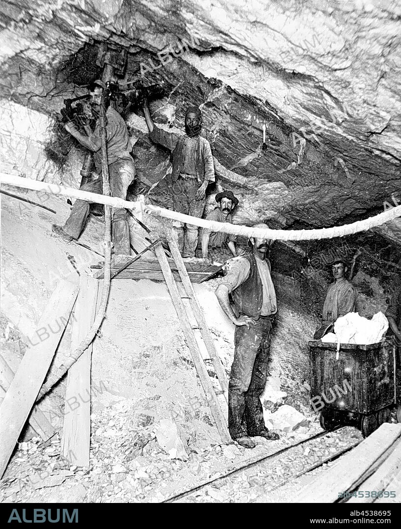 Negative - Bendigo, Victoria, circa 1908, Miners in the eastern leg of the Hustlers No 1 gold mine at 1329 feet beneath the surface. There is a filled trolley on the right.