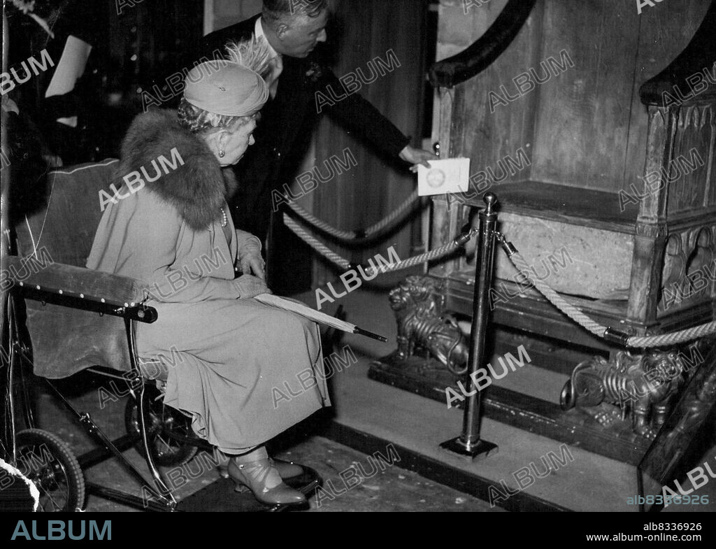 Queen Mary Wheeled To See "Coronation Stone" -- Queen Mary, 84, is pictured as she inspects replicas of the coronation stone and chair from a wheel chair at London's British Industries Fair, at earl's court, today May 1. Earlier in her tour of the exhibits Queen Mary walked. Three of her grandchildren, the young Duke of Kent, his brother Prince Michael, and his sister Princess Alexandra, walked beside of Kent and the Duke and Duchess of Gloucester. The king and Queen also toured the Exhibition. Pointing out some of the features of the reproductions I. C. B. Horley, Managing Director of Tibbenham's Furniture Company. May 16, 1951. (Photo by Associated Press Photo).