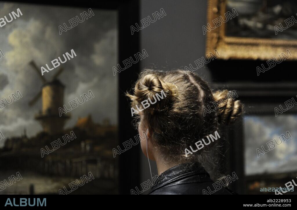 Muchacha observando el cuadro de JACOB RUYSDAEL (1628-1682), "El Molino de Wijk bij Duurstede", 1670. Rijksmuseum. Amsterdam. Paises Bajos.