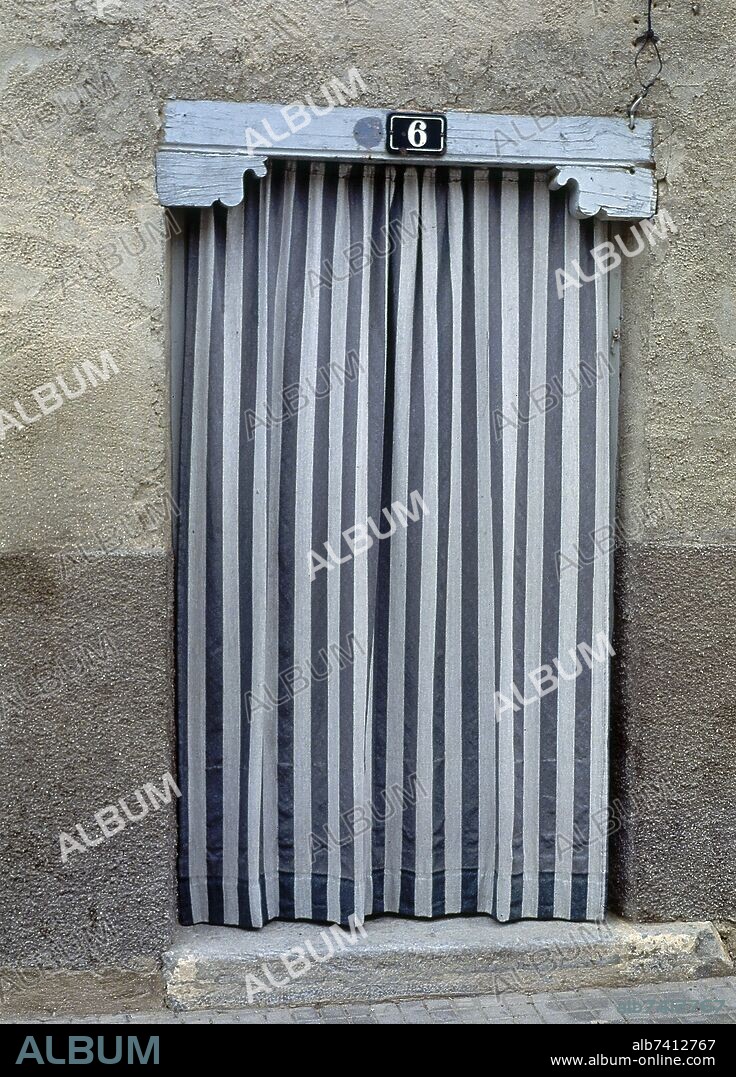 CORTINAS RAYADAS EN LA PUERTA DE UNA CASA.