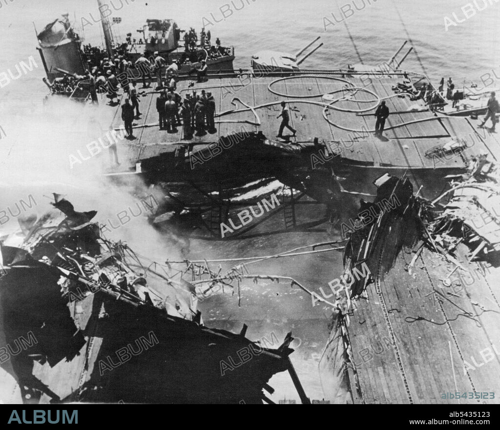 A 500-pound bomb, released by one of the attacking suicide planes before it crashed into the flight deck, hit near the deck-edge elevator and penetrated into a pilot's ready room below. Smoke still rises from the gaping hole left by the bomb which killed several of the ship's pilots. June 21, 1945. (Photo by ACME).