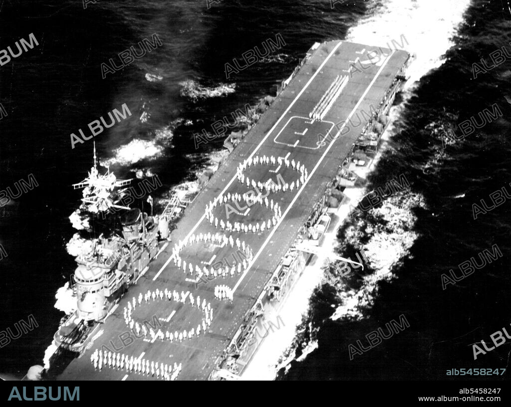 HMAS Sydney marks the 10,000th Landing of an Aircraft on her Deck -- To celebrate this event, which occurred in the pacific ocean as the carrier was returning from the United Kingdom with the Australian and New Zealand Coronation Contingents, members of the ship's company in white uniform formed the figure "10,000" on the deck. They were supported by the two contingent ahead and astern. This photograph was taken from as anti-submarine Firefly aircraft of 817 squadron which is embarked in the Sydney. A Large number of landing were made while the ship was serving with United Nations Forces in Korea. She will join those forces again in shortly following her arrival back in Sydney. July 18, 1953.