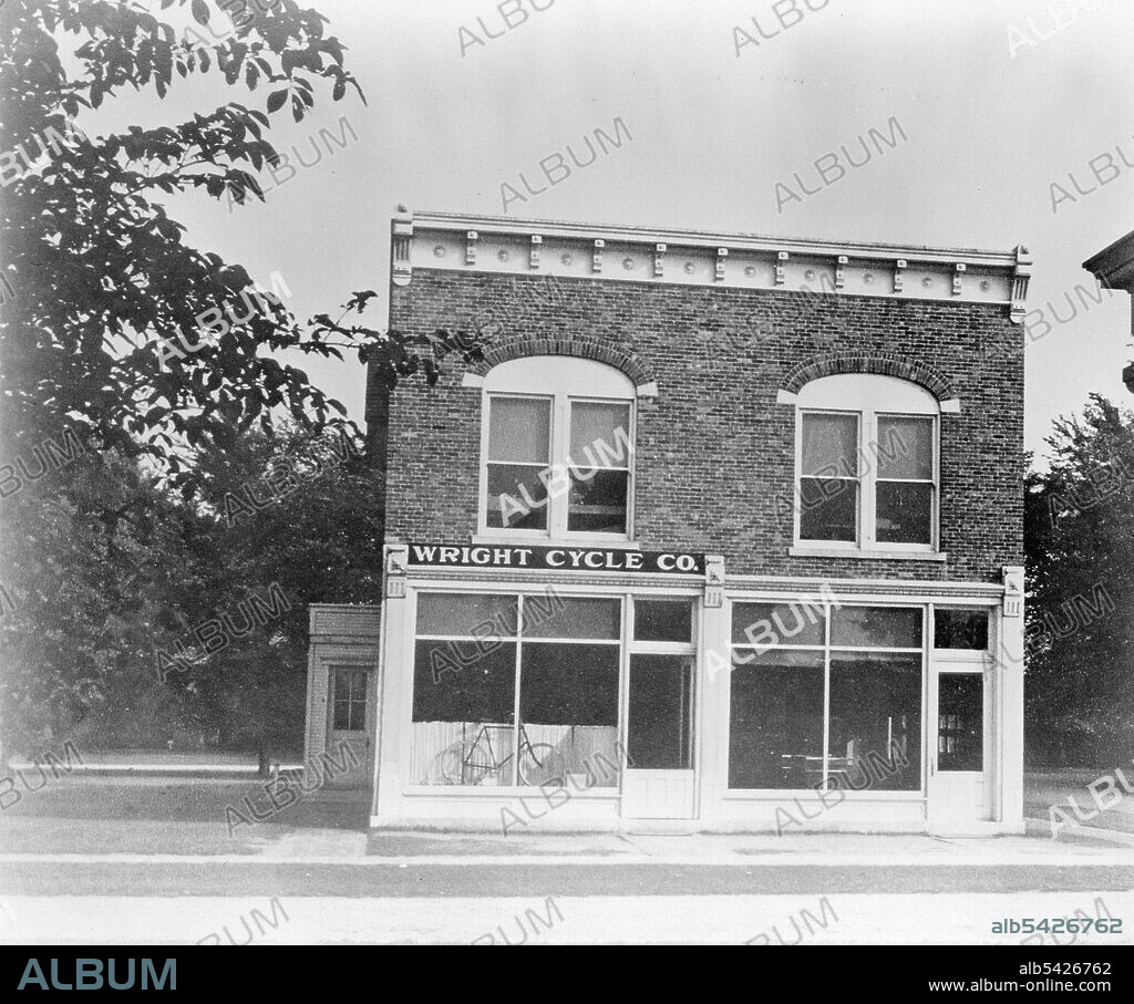 Wright Brothers Bicycle Shop, 1937. After a brief stint in the printing business, Orville and Wilbur Wright opened a bicycle sales and repair shop called the Wright Cycle Exchange at 1005 West Third Street in Dayton, Ohio, in 1892. After initially only selling and repairing bicycles, they began to make modifications on bicycles and to build their own models. They also took custom orders from their patrons. Still used today, their revolutionary oil-retaining wheel hub and coaster brakes made early bicycling easier and more comfortable. This photograph shows the Wright Cycle shop as it looked in 1937 after being moved to the Henry Ford Museum at Greenfield Village in Dearborn, Michigan. Behind the original shop, located at 1126 W. Third Street in Dayton, the Wrights assembled a frame addition where they built their first airplane.