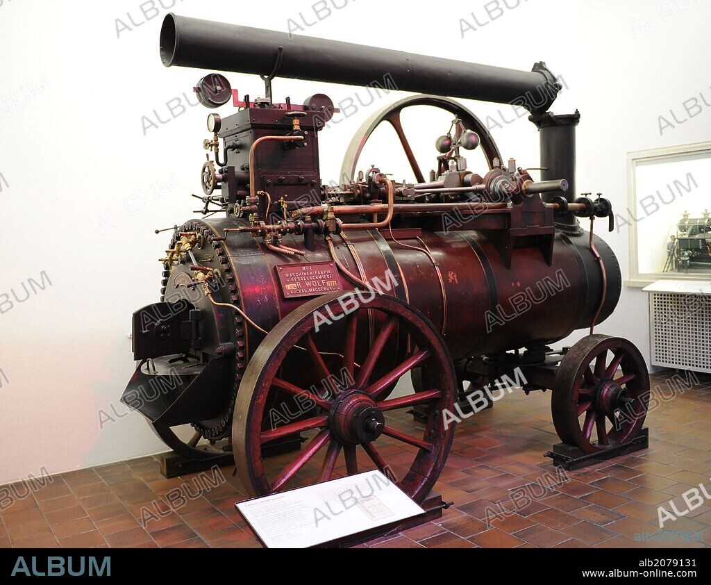 Máquina de vapor móvil de trabajo, 1862-1887, para conducir trilladoras en la agricultura. El motor de vapor de movimiento alternativo de un solo cilindro se coloca por encima de la caldera, que se calienta con madera. Fabricante: Maschinenfabrik Rudolf Wolf, Magdeburg Buckau de 1862. Presión de vapor: 6 bar. Velocidad: 120 RPM. Potencia 5,8 kW. Deutsches Museum (Museo Alemán), Munich, Baviera, Alemania. Europa.