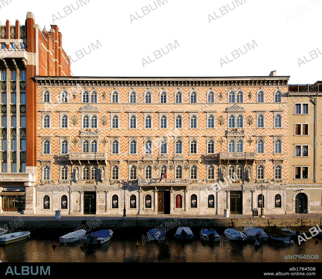Palazzo Gopcevich Trieste, by Giovanni Berlam, 1850, 19th Century, inlaid marble and stone,. Italy, Friuli Venezia Giulia, Trieste, Palazzo Gopcevich. All. Exterior view Palazzo Gopcevich white and red zig zag decoration on facade Greek key pattern above plain rusticated base doorway balcony windows small arches pilasterpediment statues.