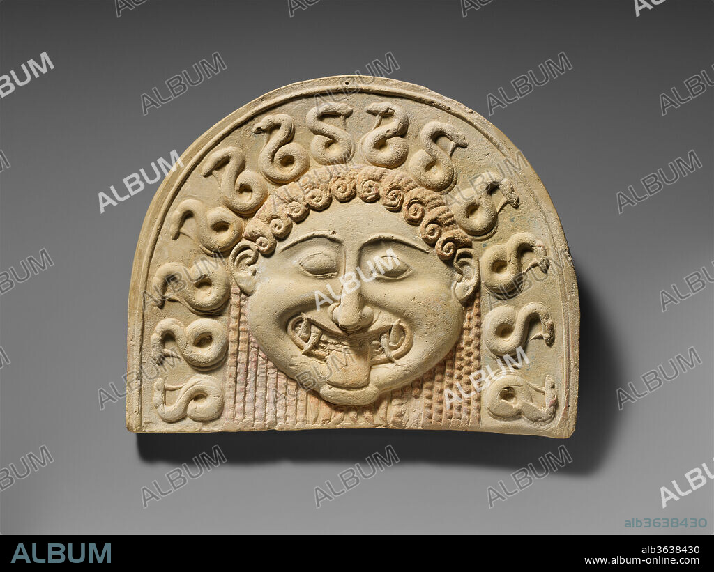 Terracotta painted gorgoneion antefix (roof tile). Culture: Greek, South Italian, Tarentine. Dimensions: H. 8 1/4 in. (21 cm.)
W. 10 5/16 in. (26.2 cm.)
Depth as preserved 3 11/16 in. (9.4 cm.). Date: ca. 540 B.C..
The clear modeling and the vivid traces of paint make this antefix a fine example of its kind. Although the colors (yellow, red, and blue) may appear faded now, their original hue would have been rich and pronounced, appropriate for the frightful theme and its high placement along the roof of a temple. The Gorgon functioned as a protective symbol and thus was an appropriate decoration for sacred architecture.