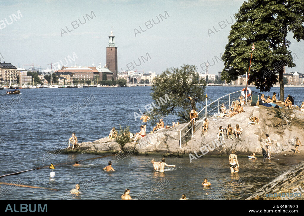 ARKIV STOCKHOLM 1975.. Människor badar vid Långholmsbadet i Stockholm en sommardag 1975 med Norr Mälarstrand och Stadshuset i fonden.. Foto: SVT Bild / Kod: 5600. Sthlm nyheter Ö.
