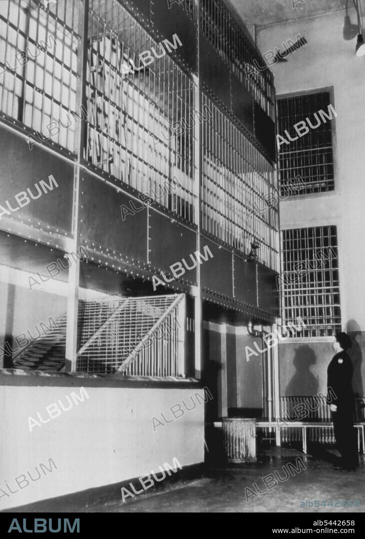Where Coy Started Riot On "Rock" -- Prison Guard (Unidentified) looks up at bars (arrow), where Convict Bernard Coy climbed, spread them apart to get into upper gun gallery and slug Prison Guard Bert Burch to obtain weapon and keys to start the rioting. May 5, 1946. (Photo by AP Wirephoto).