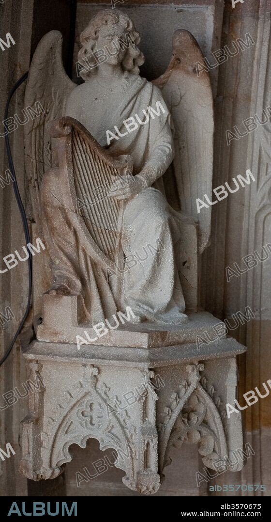 Escultura de un ángel de la música encima de un dosel, en la arquivolta del portón neogótico de la catedral de Barcelona, Siglo XIX, Barcelona, Cataluña, España.