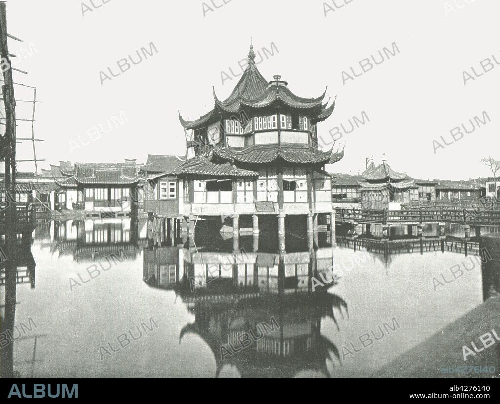 'One of the Public Tea-Gardens', Shanghai, China, 1895. Teahouse on stilts reflected in a lake. From "Round the World in Pictures and Photographs: From London Bridge to Charing Cross via Yokohama and Chicago". [George Newnes Ltd, London, 1895].