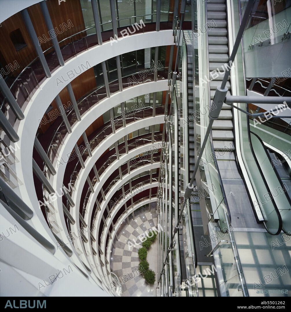 JOHN LAING PLC. 3 Minster Court, Mincing Lane, City of London, 28/09/1993. Looking down into the central atrium of 3 Minster Court, showing the curved balconies and suspended escalators. In October 1990, Laing’s London division were awarded the contract for the fitting out of the new London Underwriting Centre at No.3 Minster Court. Key parts of the contract included altering steelwork to enable 16 escalators to be suspended in the atrium, creating dining and kitchen areas on the mezzanine level and the installation of raised floors and suspended ceilings. In August 1991, the team faced a huge setback as the site was severely damaged by fire. The flames swept through the central atrium and burst through the roof. A new Laing team was formed to restore the building after the disaster, and work was finally completed in late 1993.