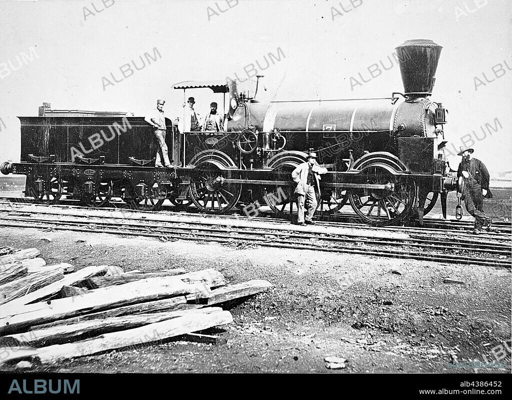 Negative - Victoria, circa 1865, Men standing on and beside the P-class 0-6-0 type steam locomotive No.7. The men were probably railways staff, including a loco crew. A pile of railway sleepers appear in the foreground. No.7 was a goods locomotive built by Beyer Peacock, Manchester in 1859.
