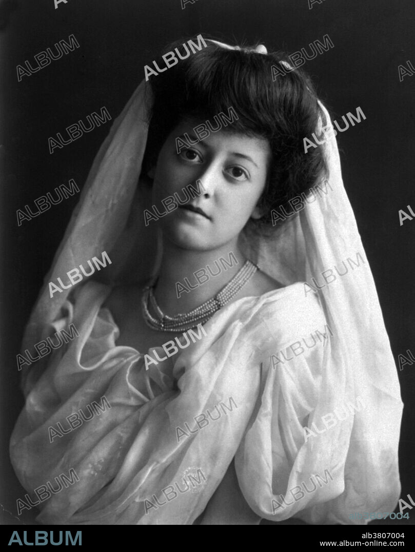 Entitled: "Young woman modeling wedding gown" photographed by Fitz W. Guerin, 1902. A wedding dress or wedding gown is the clothing worn by a bride during a wedding ceremony. Color, style and ceremonial importance of the gown can depend on the religion and culture of the wedding participants. In Western cultures, brides often choose a white wedding dress, which was made popular by Queen Victoria in the 19th century. In eastern cultures, brides often choose red to symbolize auspiciousness.