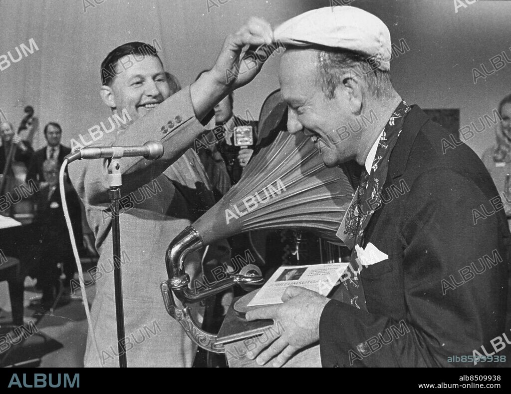 21 september 1975. Gösta Nordgren kallad 'Snoddas' hyllar Lennart Hyland på den senares 50-årsdag med en gammal trattgrammfonon och sin gamla bandykeps. 'Man måste ändå ha hjälm på sig numera' sade Snoddas. *** Local Caption *** . Kamerareportage.