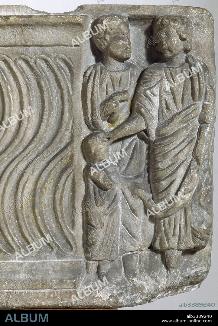 Escultura paleocristiana. Sarcófago estrigilado de mármol blanco, decorado con escenas del Nuevo Testamento. Detalle de uno de los relieves del extremo del sarcófago con la representación de dos adultos y un niño (siglo IV d. C.). Procedente de Barcelona. Museu d'Arqueologia de Catalunya. Barcelona.