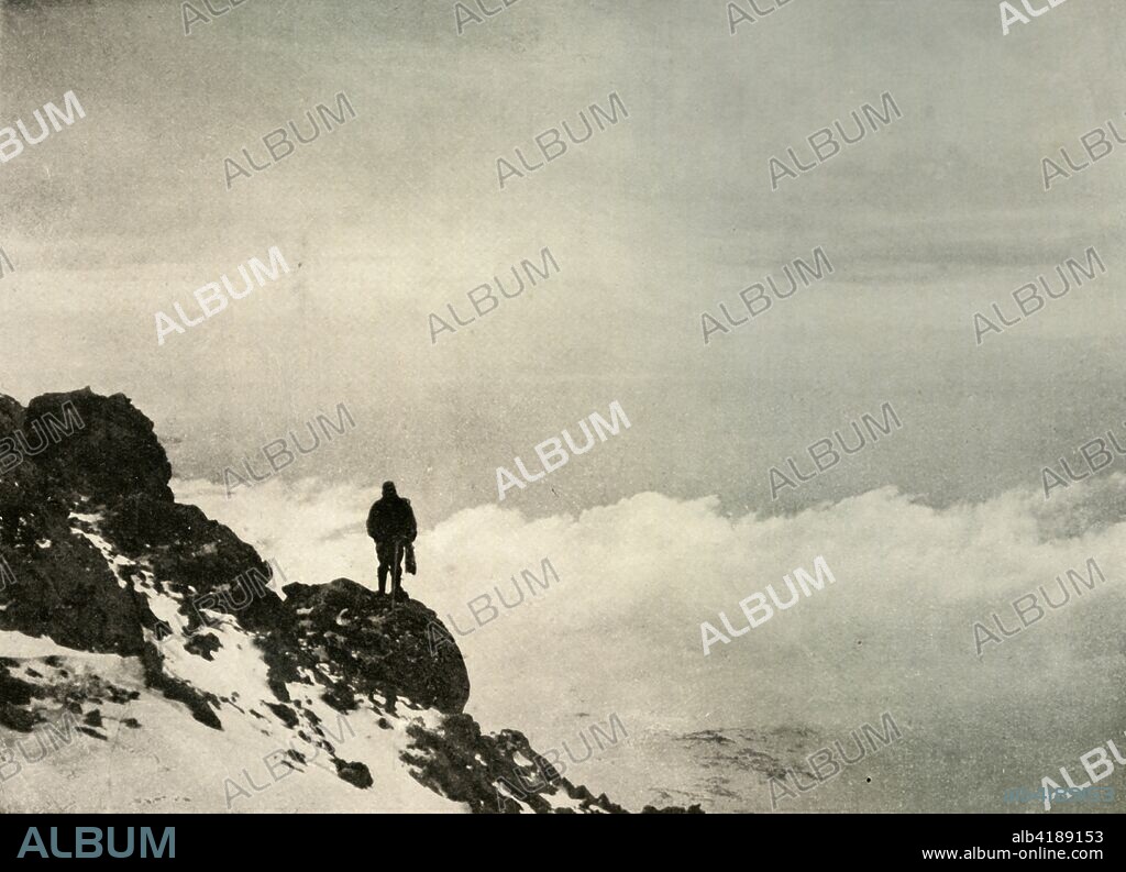 'Brocklehurst Looking Down From A Point 9000 Feet Up Mount Erebus. The Clouds Lie Below, and Cape Royds Can Be Seen', 1908, (1909). Philip Brocklehurst was a member of the expedition which achieved the first ascent of Mount Erebus, Antarctica's second highest volcano. Anglo-Irish explorer Ernest Shackleton (1874-1922) made three expeditions to the Antarctic. During the second expedition, 1907-1909, he and three companions established a new record, Farthest South latitude at 88°S, only 97 geographical miles (112 statute miles, or 180 km) from the South Pole, the largest advance to the pole in exploration history. Members of his team also climbed Mount Erebus, the most active volcano in the Antarctic. Shackleton was knighted by King Edward VII for these achievements. He died during his third and last 'oceanographic and sub-antarctic' expedition, aged 47. Illustration from The Heart of the Antarctic, Vol. I, by E. H. Shackleton, C.V.O. [William Heinemann, London, 1909].