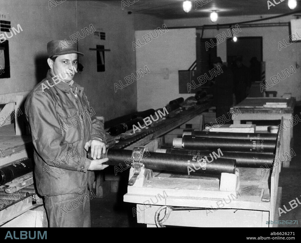 A soldier of the U.S. army shows projectiles on conveyer belts in the vigilantly guarded munitions depot Miesau on 2 February 1961. 02/02/1961