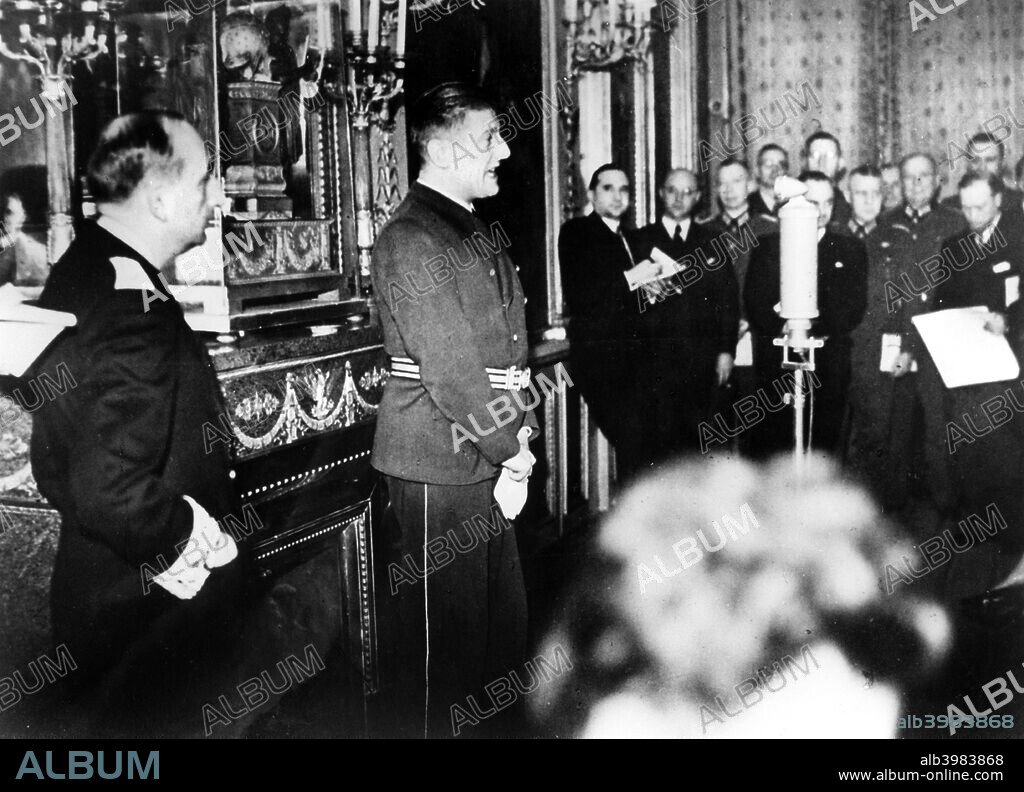 German Ambassador to Vichy France, Otto Abetz, delivering a press conference, 15 December 1940. He is speaking on the subject of the transfer of the body of the Emperor Napoleon II from Vienna to Paris, a gift from Hitler to the Vichy regime. On the left of the photograph is Fernand de Brinon, a leading French collaborator during the Nazi occupation who was tried as a war criminal by the French after the liberation and executed in 1947.