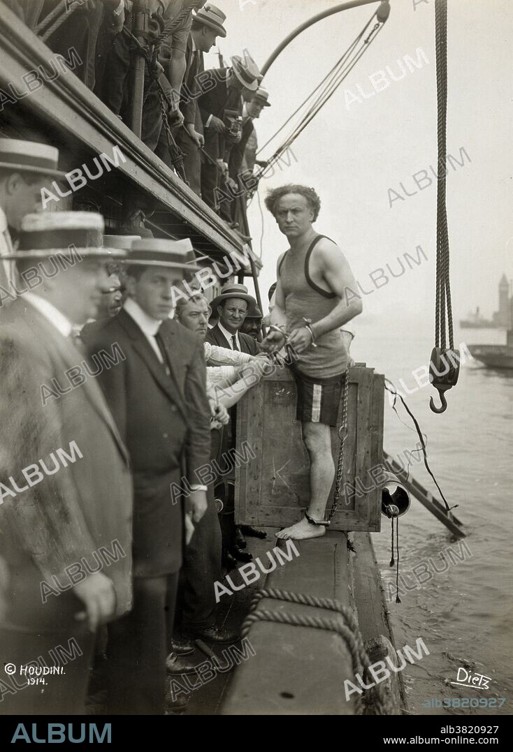Entitled: "Harry Houdini stepping into a crate that will be lowered into New York Harbor as part of an escape stunt on July 7, 1912" photographed by Carl Dietz. Harry Houdini (March 24, 1874 - October 31, 1926) was a Hungarian-American illusionist and stunt performer, noted for his sensational escape acts. He began his magic career in 1891. He focused initially on traditional card tricks and billed himself as the "King of Cards". He soon began experimenting with escape acts. He first attracted notice as "Harry Handcuff Houdini" on a tour of Europe, where he challenged police forces to keep him locked up. Soon he extended his repertoire to include chains, ropes slung from skyscrapers, straitjackets under water, and having to hold his breath inside a sealed milk can. He concealed the exact details of his escapes to maintain an air of mystery and suspense. As President of the Society of American Magicians, he was keen to uphold professional standards and expose fraudulent artists. He was also quick to sue anyone who pirated his escape stunts. Houdini died of peritonitis, secondary to a ruptured appendix at the age of 52.