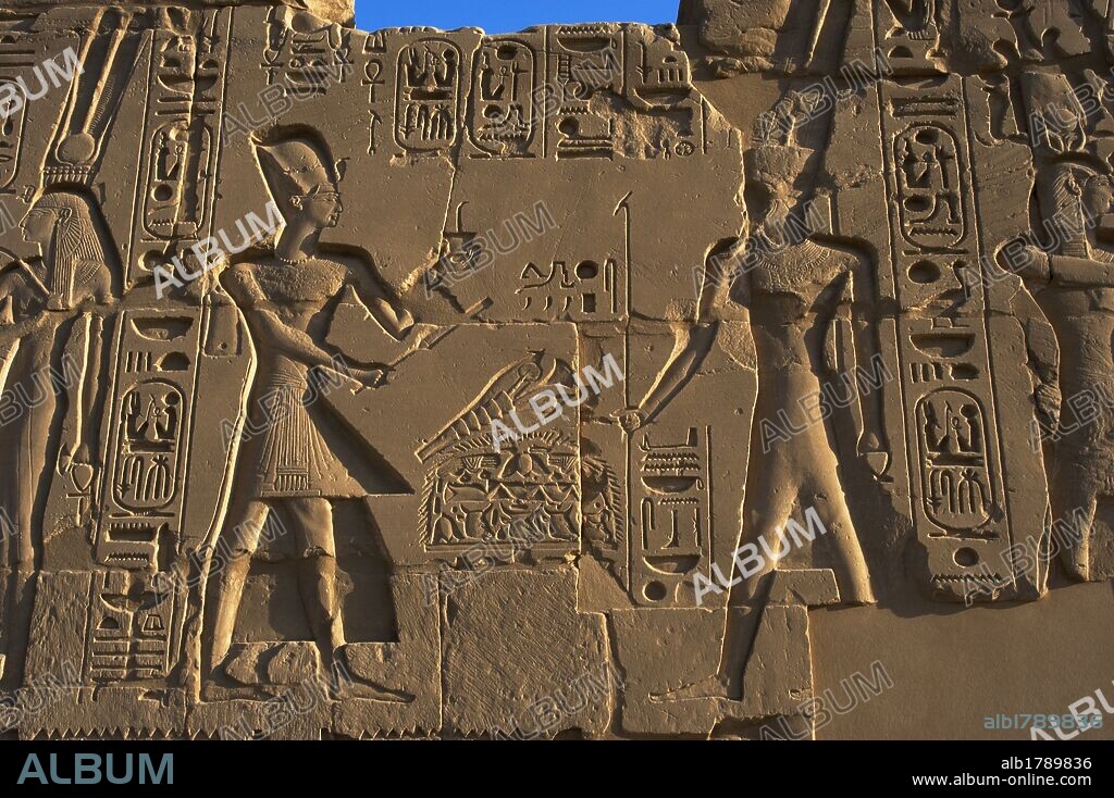 ARTE EGIPCIO. EGIPTO. Relieve de un muro del TEMPLO DE KARNAK, con la representación del faraón RAMSES II (XIX Dinastía), con yelmo o corona del tipo khepresh realizando una OFRENDA AL DIOS AMON. Imperio Nuevo. Noroeste de Luxor. Egipto.