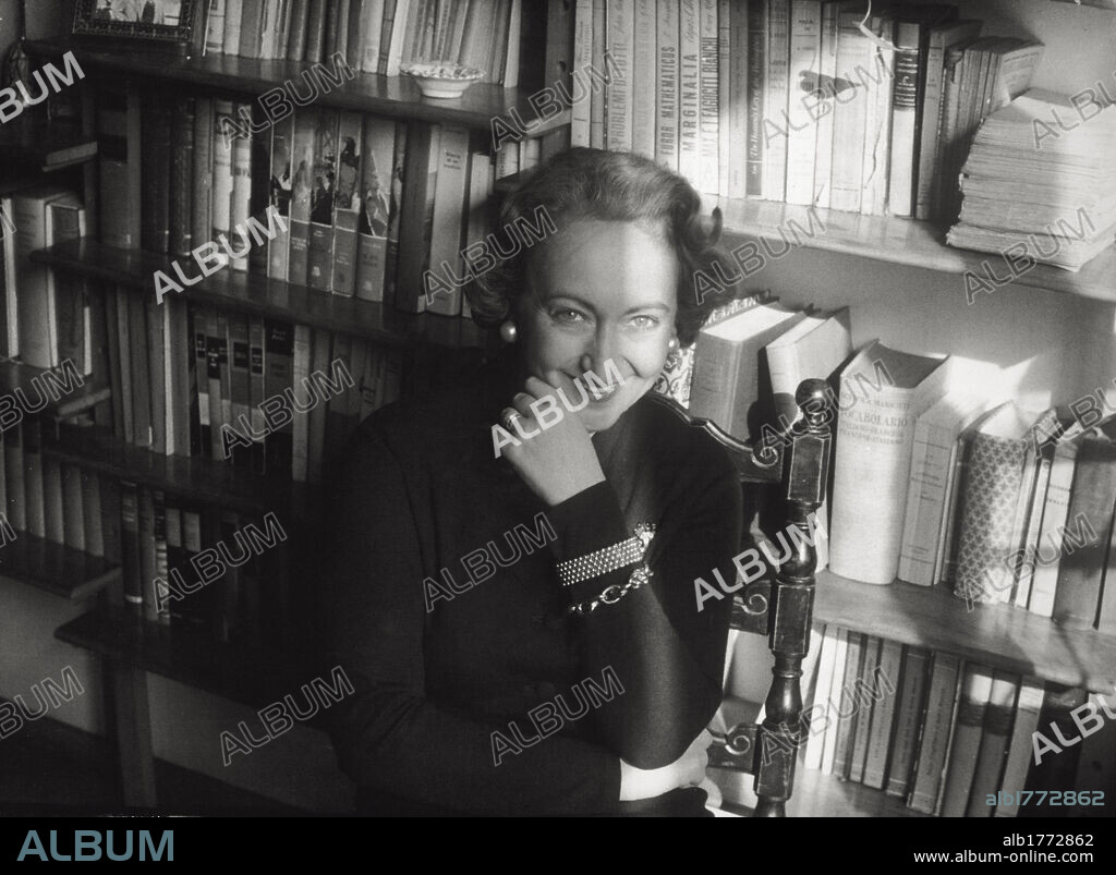 Alba de Céspedes in Milan. The Italian writer Alba de Céspedes y Bertini photographed in front of a bookshelf in a house in Milan, the city where she would publish all her books from the late 1930s onwards. Milan, January 1957.