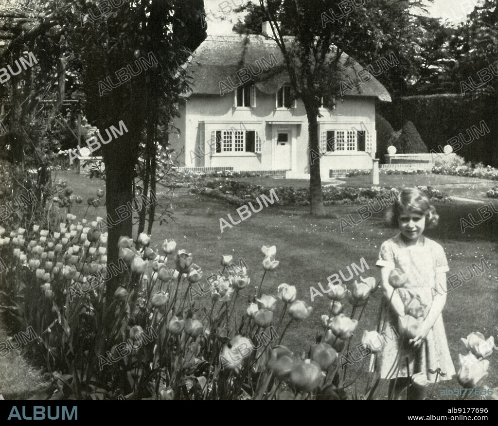 'Y Bwthyn Bach', 1936, (1947). The future Queen Elizabeth II at the 'Little Cottage', a wendy house which was presented to her on her sixth birthday by the people of Wales. It was erected in the gardens of the Royal Lodge at Windsor. From "Princess Elizabeth: The Illustrated Story of Twenty-one Years in the Life of the Heir Presumptive", by Dermot Morrah. [Odhams Press Limited, London, 1947].