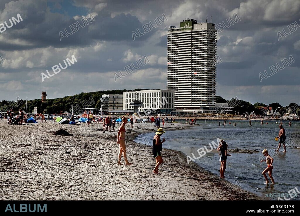 Baltic Sea beach of the peninsula Priwall at the mouth of the river Trave, sandy beach, vacationers, bathers, high-rise building in Travemünde, sea, Kolonnenweg, Lochplattenweg, inner-German border fortification, Grünes Band, border path, Travemünde, Lübeck, Schleswig-Holstein, German