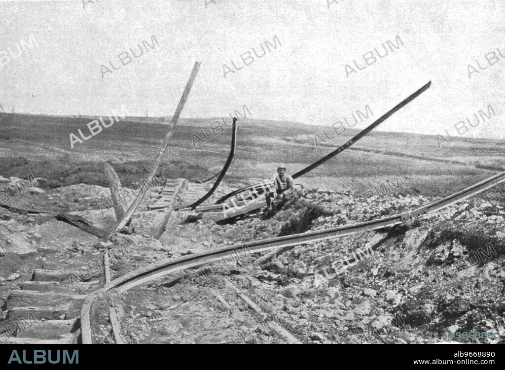 'Devant Verdun; Entre Fleury et Thiaumont, sur la voie du chemin de fer d'interet local qui tournait a droite vers Vaux, rails souleves et tordus par les explosions de projectiles: au fond, la hauteur de Douaumont', 1916. From "Collection de la Guerre IV. L'Illustration Tome CXLVIII. La Guerre Juillet, Aout, Septembre, Octobre, Novembre, Decembre 1916".