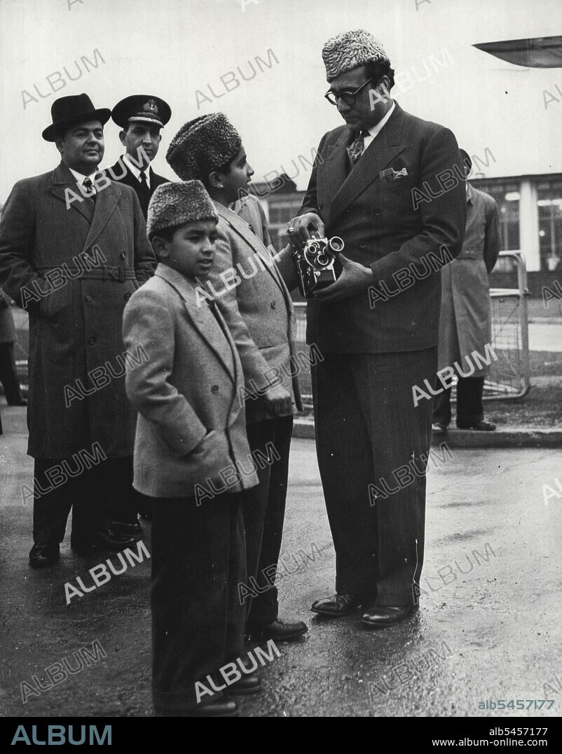 High Commissioner Helps a Young Cameraman -- Mr. Habib Ibrahim Rahimtoola, the Pakistan High Commissioner in London, helps a young photographer adjust his cine camera at London Airport today (Friday). The young man 13-year-old Ashraf, son of the Pakistan Prime Minister Liaquat Ali Khan. With him is his nine-year-old brother, Akear.They were at the airport to see their father off on his journey home. The Prime Minister left by K.L.M. aircraft for Amsterdam on the first stage of his return trip. He was in London attending the Commonwealth Prime Minister's Conference. January 19, 1951. (Photo by Reuterphoto).