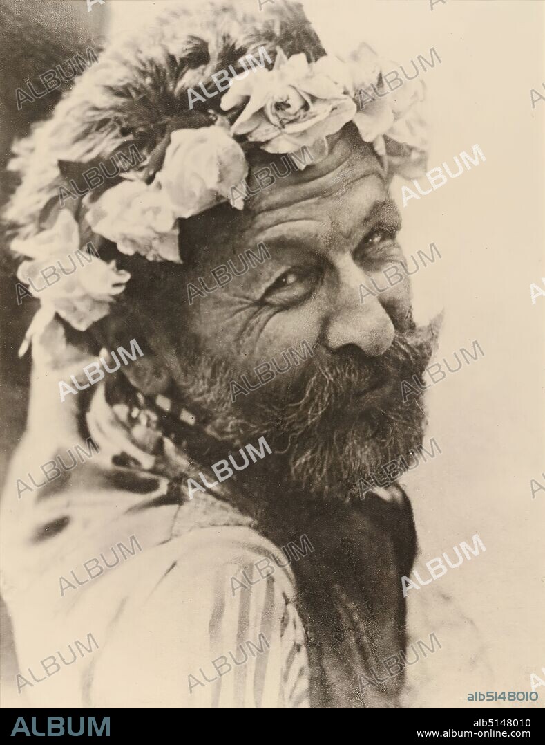 Hugo Erfurth, Richard Dehmel, from the album Ausstellung Hugo Erfurth - Bildnisse aus dem XX. Jahrhundert, Konstanz 1949, silver gelatin paper, black and white positive process, passepartout : height: 22.8 cm; width: 17.5 cm, inscribed: Passepartout recto u. in the middle: in typescript on Japan paper: H u g o E r f u r t h, '''Richard Dehmel'', stamp: Passepartout verso and left: inscribed: Passepartout verso and: in lead: (around 1910), gelatin silver, repro no, portrait photography, portrait, wreath, garland, At the beginning of the 20th century, Hugo Erfurth, along with Rudolph Dührkoop and Nicola Perscheid, was one of the most famous professional photographers in Germany. After completing an apprenticeship as a photographer, he opened his own studio in Dresden at the age of only 22. Soon Erfurth orientated himself towards the up-and-coming pictorialist photography, participated in numerous amateur photographic exhibitions from 1894 onwards and managed to make a name for himself both as an artistically ennobled amateur and successful professional photographer. Portraits are central to his work, which he began taking in 1906 in his new studio, a classicist palace, in a stylishly elegant ambience, appealing to the wealthy bourgeoisie. He also produced numerous portraits of famous personalities, including Käthe Kollwitz, Otto Dix and Joachim Ringelnatz. While his studies around 1905 still show full-length figures depicted in an atmospheric way, from the 1920s onward the focus is on the face, which is photographed against a simple monochrome background. Here, his pictorial approach corresponds to the portrait of classical modernism, whereby the technique of oil printing emphasizes the softness and materiality of the pigments and at the same time places the portraits in the art-photographic tradition. Erfurth is a co-founder of the Gesellschaft Deutscher Lichtbildner (1919), teaches at the Leipzig Academy and moves from Dresden to Cologne in the 1930s, where he bui.
