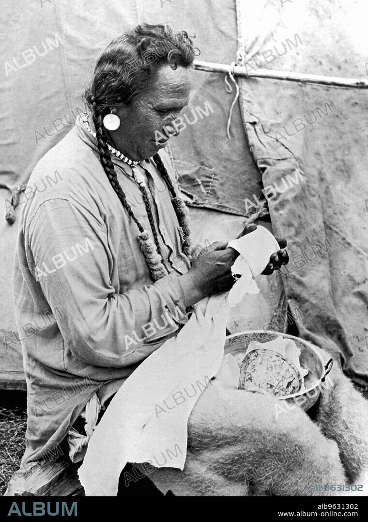 Glacier National Park, Montana, c 1925 Chief Heavy Breast takes over the dish chores when his wife goes to the agency twice a month for their sewing circle.