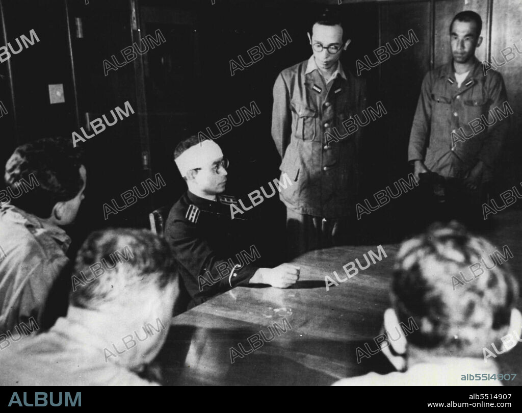 Tells Hiroshima Story -- Hirokuni Dazai, Leader of the Hiroshima ***** relates his version of the atomic bombing of Hiroshima. He arrived in the devastated city forty minutes after the bomb exploded - he was injured by falling timber while doing rescue work.Standing at Dazai's left is an interpreter. September 13, 1945. (Photo by Associated Press Photo).
