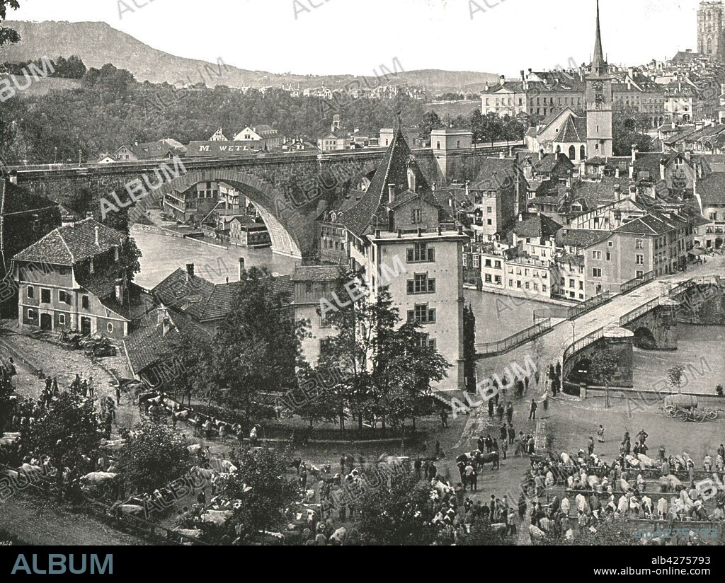 The Nydeggbrücke and cattle market, Bern, Switzerland, 1895. Bridges over the river Aare, with cattle being sold in the foreground. From "Round the World in Pictures and Photographs: From London Bridge to Charing Cross via Yokohama and Chicago". [George Newnes Ltd, London, 1895].