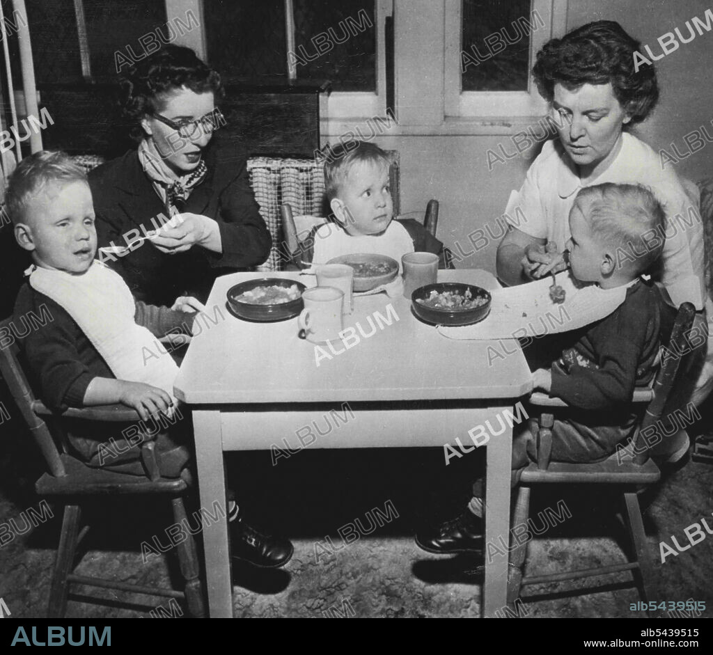 Blind Triplets Have Lunch - Harry, Larry and Barry Terry (L to R) blind triplets from Stearns, KY., have their first lunch at the Boston nursery for blind babies. The tots, who will be three years old Sunday, arrived here last night to start a three year training course financed by friends in Kentucky. Miss Mildred Sloan who accompanied children from Kentucky is at left. Nurse Amelia S. Reed of the nursery staff is at right. Doctors here will examine the boys, blind since birth, to see if there.