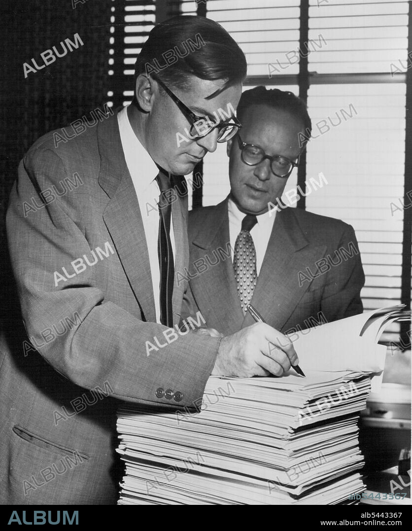 Australia Signs decision on 6 Nations to G.A.T.T. -- At United Nations Headquarters in the presence of Mr. A.H. Feller (right), Principal Director of the U.N. Legal Department, Mr. Keith Shann, Australian representative to U.N., signs on behalf of his government decisions agreeing to the accession of Australia, the German Federal Republic, the Republic of Korea, Peru, the Philippines and Turkey to the General Agreement on Tariffs and Trade (GATT). June 18, 1951. (Photo by U Nations).