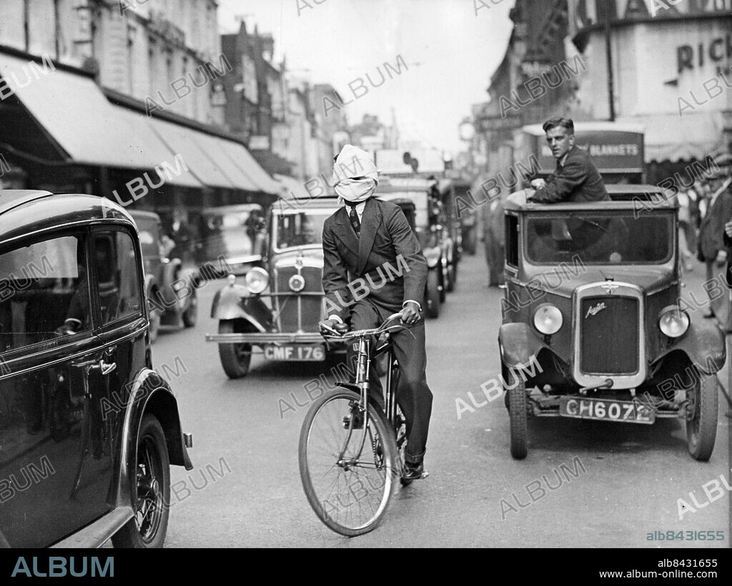 Orig. bildtext... INDIAN MYSTIC RIDES BLIND THROUGH LONDON TRAFFIC. Eyes sealed by a mass of dough mixed with cotton wool and bandaged, Kuda Bux, the Indian mystic and firewalker, astounded drivers, policemen and pedestrians by riding a bicycle safely through the thickest traffic in Hammersmith, London. He carried out the ride as a demonstration of his uncanny sense of direction and balance. Photo shows: Kuda Bux riding blindfold through the traffic in King Street, Hammersmith, London. Beneath the bandage his eyes are sealed by a thick mixture of dough and cotton wool. Anm. Ögonbindel Blindbock Magiker Bandage Se även BAX772 persons: Kuda Bux sites: INDIEN* ;LONDON ;STORBRITANNIEN.