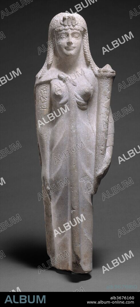 Statue of a Ptolemaic Queen, perhaps Cleopatra VII. Dimensions: H. 62.5 cm (24 5/8 in.); W. 22 cm (8 11/16 in.); D. 15 cm (5 7/8 in.). Dynasty: Ptolemaic Dynasty. Date: 200-30 B.C..
The statue represents a Ptolemaic queen holding a cornucopia. Attributes and dress point to a date in the second or first century B.C., and one recent study notes that details of the queen's hairstyle suggest identification with Cleopatra VII. However, the cartouche actually reading "Cleopatra" on this statue's arm would be a highly unusual occurrence, and is, moreover, incorrectly oriented, so that it is probably a modern addition.