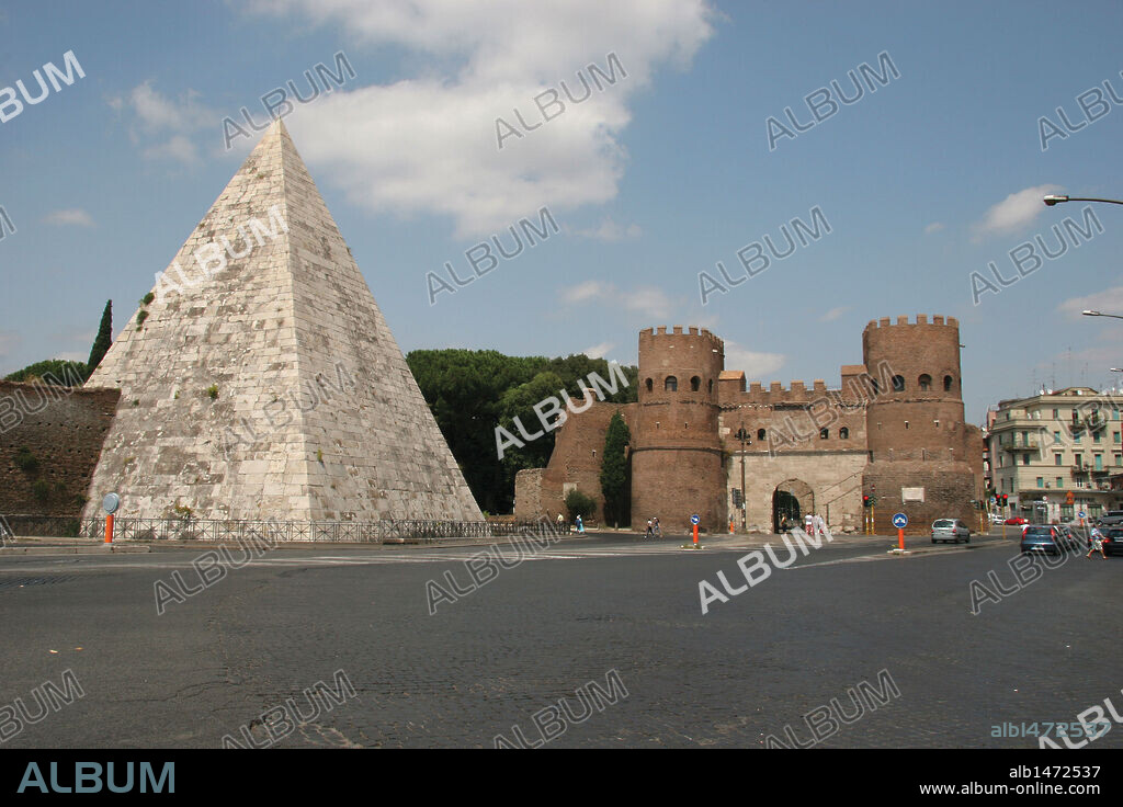 ARTE ROMANO. ITALIA. PIRAMIDE DE CAYO CESTIO (CAIO CESTIO), magistrado romano que murió en el 12 a. C. En el siglo III d. C., al igual que otros monumentos ya existentes se incorporó a la muralla Aureliana. Al fondo una de las puertas de las murallas de Roma, la antigua Puerta Ostiense, llamada actualmente Puerta de San Pablo. Por ella entraron los godos de Totilla en el año 546 d. C. Roma.