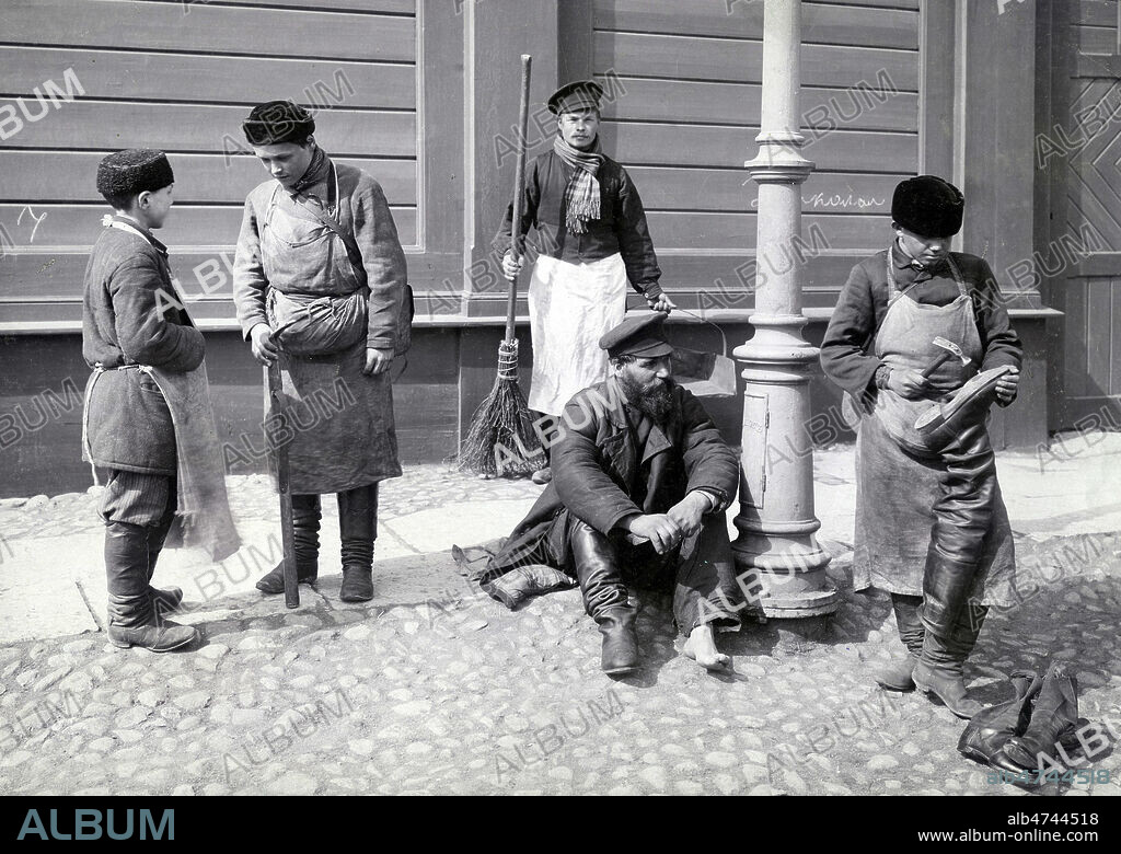 Scene de rue, Cordonnier ambulant et balayeur a Saint-Petersbourg en Russie. Photographie par Franta VITKU. Credit : Collection NBL/KHARBINE-TAPABOR.